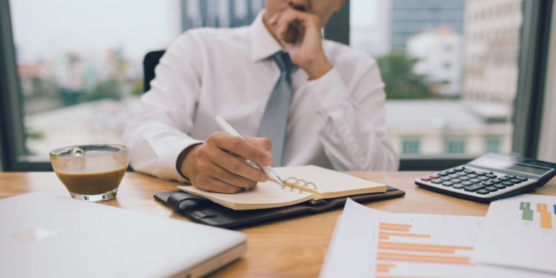 Un administrador organiza su agenda en su escritorio.