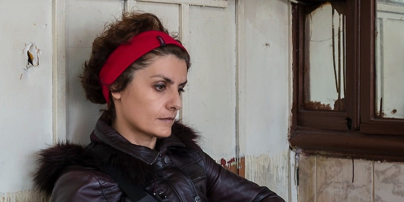 Una mujer mira el vacío con expresión apática.