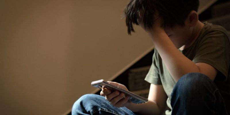 Un niño con su teléfono móvil.