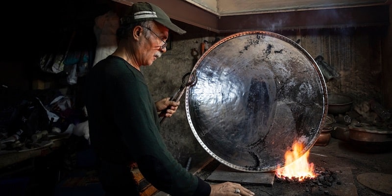Un hojalatero moldea el metal gracias a sus competencias laborales.