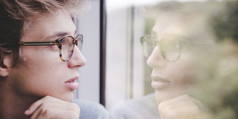 Un hombre mira por una ventana.
