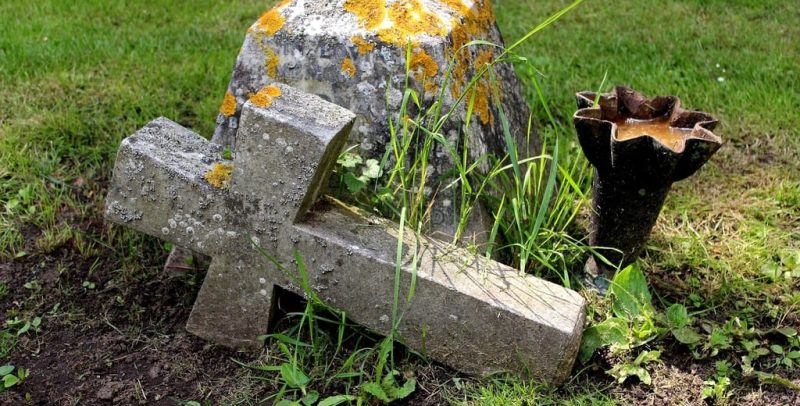 Cruz de piedra sobre el cesped. 